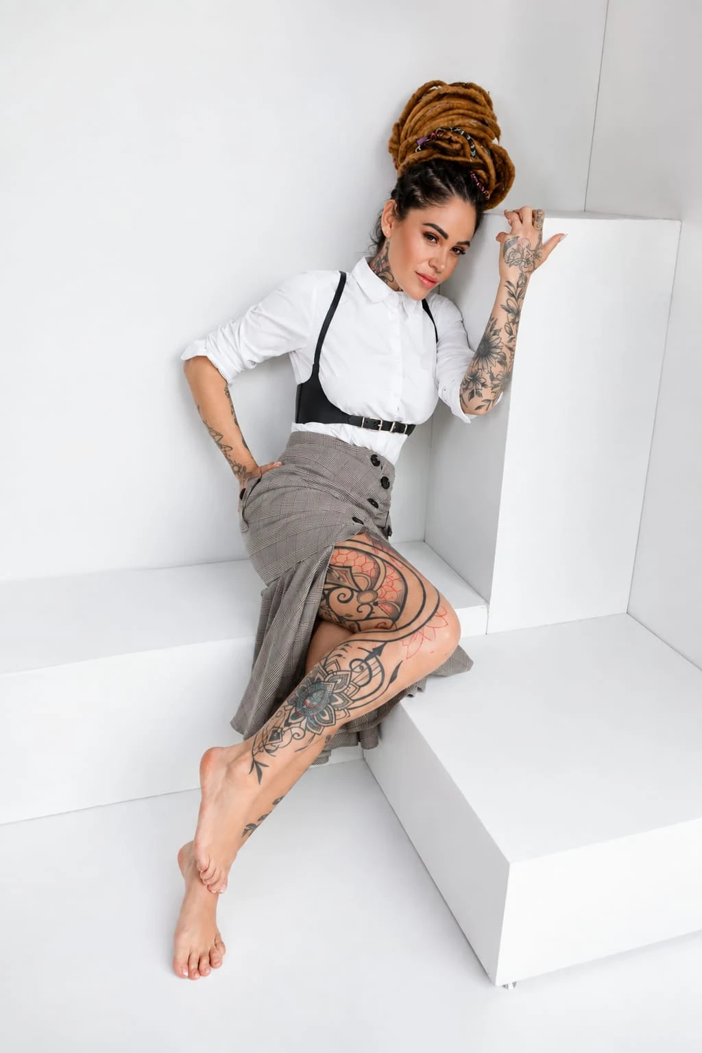Retrato editorial de Yass Noir sentada con falda gris